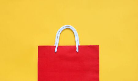 Red shopping paper bag on the yellow background with copy space. Summer sale concept.
の写真素材