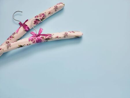 Clothes hangers on pastel blue background with copy space. Fashion feminine blog, sale, store, design, shopping concept.の写真素材