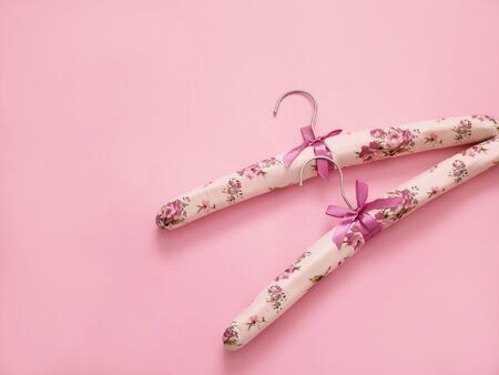 Clothes hangers on pastel pink background with copy space. Fashion feminine blog, sale, store, design, shopping concept.の写真素材