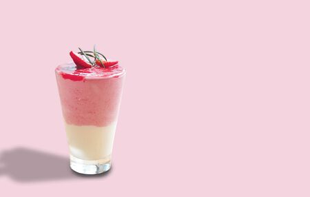 Strawberry yogurt smoothie in glass on pink pastel background. の写真素材