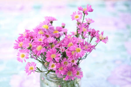 Bouquet of pink flowers in glass vase with blurry natural background.の写真素材