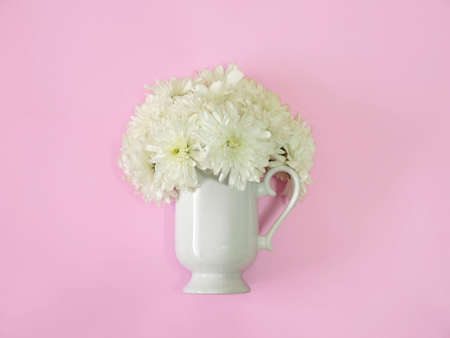 Coffee or tea cup with white flower inside on a pink background. minimal flat layの写真素材