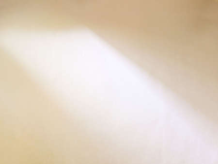 Warm beige plastered wall illuminated by sunlight with window shadowの写真素材