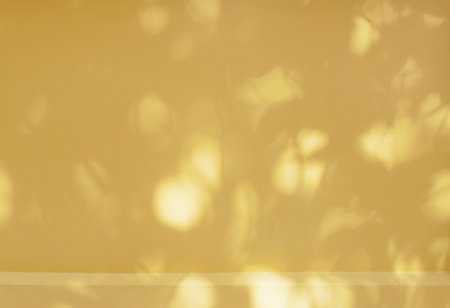 Yellow plaster wall product background presentation with nature leaves shadowの写真素材