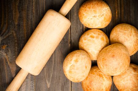 Homemade buns and rolling pin on wooden plate and