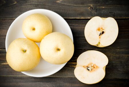 Fresh asian pear in the bowl on wooden backgroundの写真素材