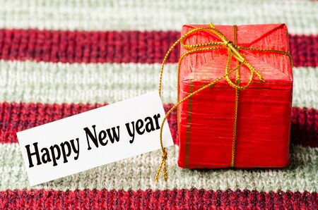 Red giftbox with happy new year text on red background