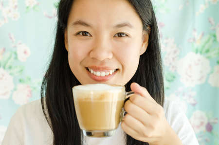 Young asian woman drinking coffee in the morningの写真素材