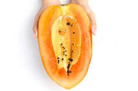Half of ripe papaya fruit hold by hand on white backgroundの写真素材