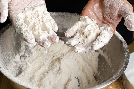 Mixing flour and yeast in the bowl by hand,bread cookingの写真素材
