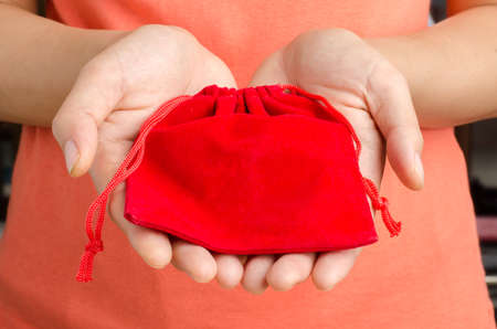 Red bag hold by hand to giving on Chinese new yearの写真素材