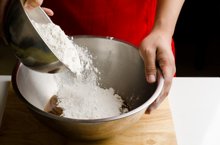 Pouring flour in the bowl for bakery cooking