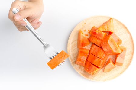 Piece of ripe papaya fruit on wooden plate ready to eatの写真素材
