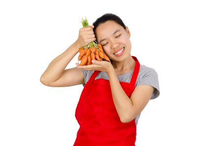 Happy woman holding carrot ready to cooking,isolated on white backgroundの写真素材