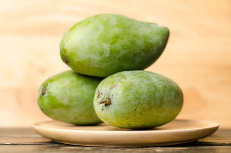 Raw mango on wooden plateの写真素材
