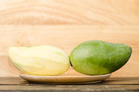 Raw mango on wooden plateの写真素材