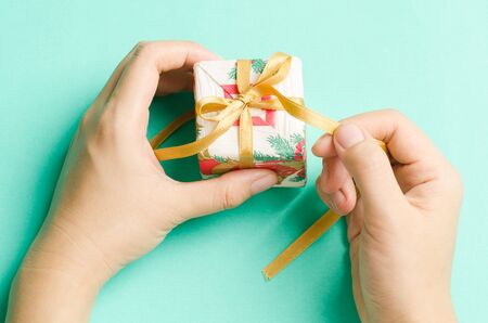 Gift box decorative with golden ribbon on green background