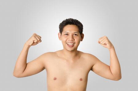 Asia strong man isolated on gray backgroundの写真素材