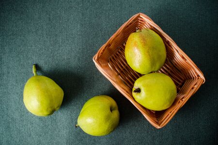 Fresh pears fruit in a basket on green background,healthy foodの写真素材