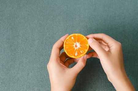 Fresh Tangerine orange fruit holding by hand ready to eating,healthy foodの写真素材