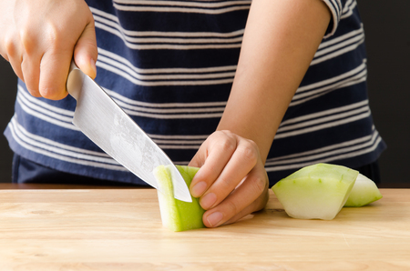 Chef cutting wax gourd on wooden board prepare for cooking Thai foodの写真素材
