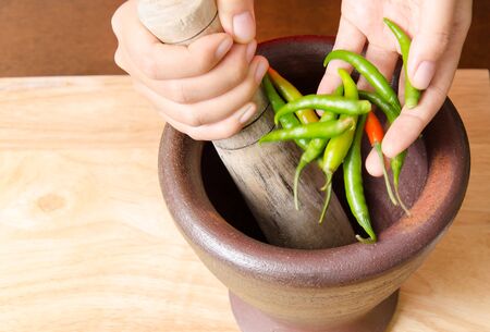 Green chili pounding in mortar prepare for Thai food cookingの写真素材
