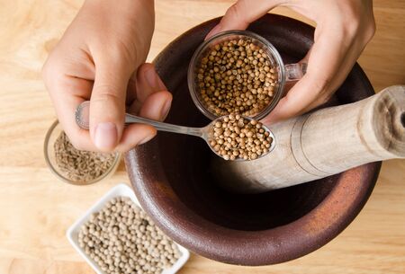 Coriander seed pounding in mortar prepare for Thai food cookingの写真素材