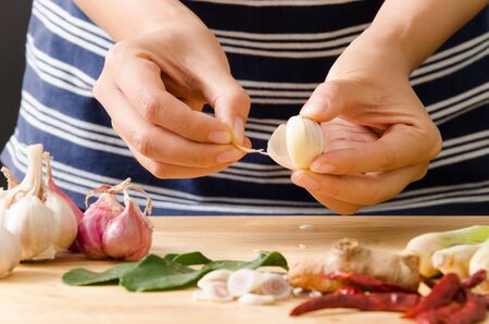 Chef peeling garlic by hand for cooking Thai foodの写真素材
