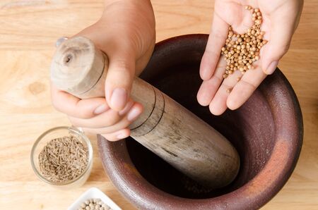 Coriander seed pounding in mortar prepare for Thai food cookingの写真素材