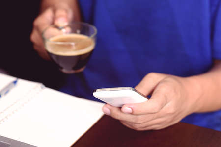 Man using smart phone for working and drink coffeeの写真素材