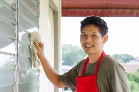 Portrait of Asian man wear red apron ready to cleaningの写真素材