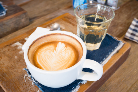 Cup of latte art coffee on wooden tableの写真素材
