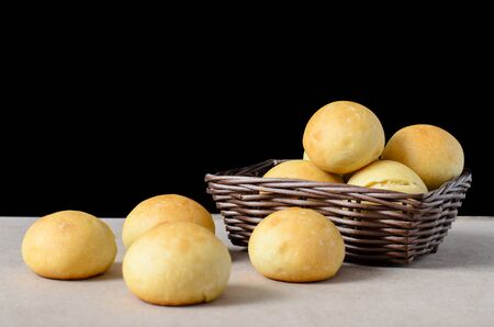 Homemade buns in a basket on black background