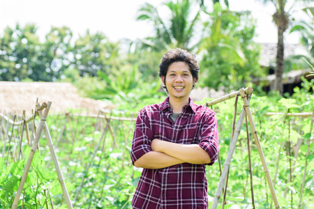 Asian young farmer standing in vegetables garden,organic farmの写真素材