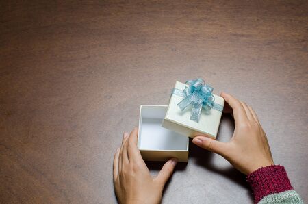 Top view of hand open gift box on wooden background