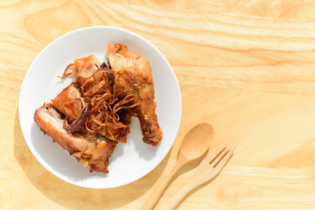 Fried chicken leg with fried onion on top ready for eatingの写真素材