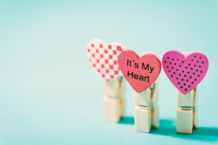 Decoration clothes pegs (heart shape) on green pastel background, Valentine day conceptの写真素材