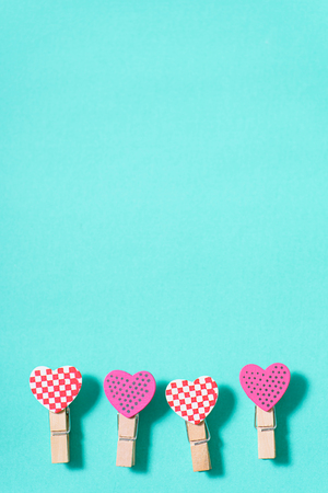 Decoration clothes pegs (heart shape) on green pastel background, Valentine day conceptの写真素材