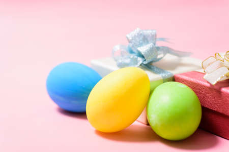 Colorful Easter eggs and gift box on pink backgroundの写真素材