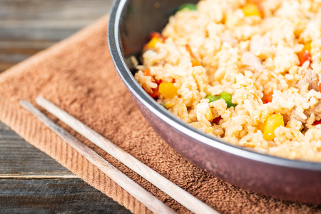 Fried rice with vegetables and pork in a pan with chopsticks, Thai cuisineの写真素材