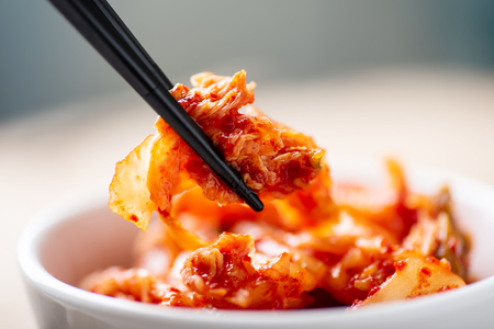 Hand holding chopsticks for eating kimchi cabbage, Korean foodの写真素材