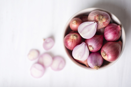 Red shallot onion in a bowl on white table, herb and spice, food ingredientの写真素材