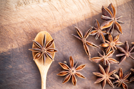 Anise star on wooden spoon and table, herb and spice, food ingredientの写真素材