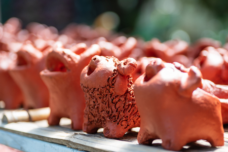 Row of smile animal clay dolls on rack in a clay shopの写真素材