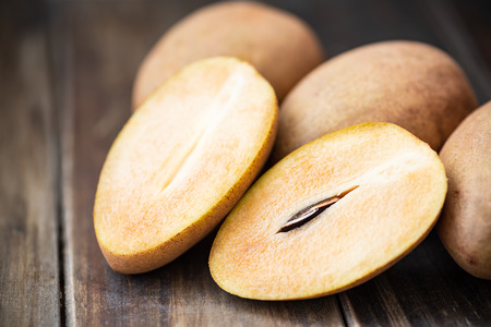 Sapodilla plum fruit on wooden table, exotic Thai fruit (La mood)の写真素材