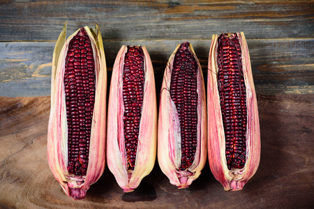 Fresh purple sweet corn on wooden backgroundの写真素材