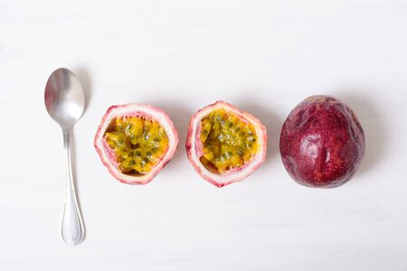 Fresh passion fruit and spoon on white background, tropical and healthy fruit