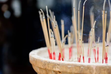 Incense sticks burning in old pot in the templeの写真素材