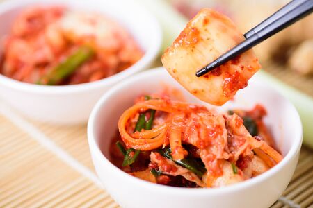 Eating kimchi cabbage in a bowl by chopsticks, Korean foodの写真素材