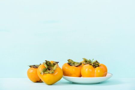 Fresh persimmon on pastel background with copy spaceの写真素材